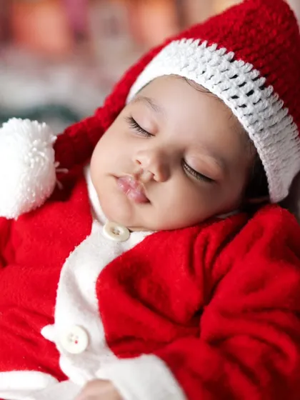 A tiny Santa sleeping peacefully. Our Christmas shoots are perfect for newborns too, creating the most adorable holiday cards.