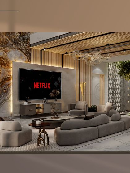 The perfect setup for a movie night at home. This living room features a large screen, a comfortable curved sofa, and a beautiful marble accent wall, blending entertainment and high design.