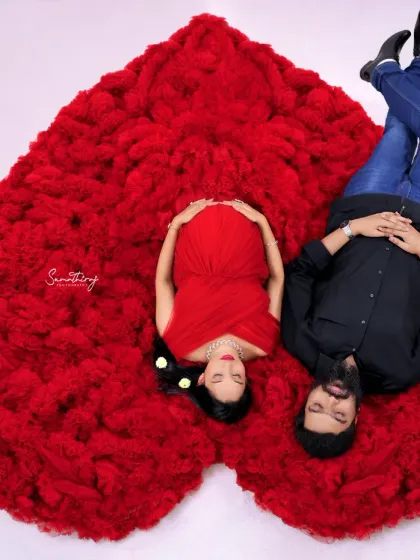 A creative top-down shot of a couple, with the red gown forming a heart shape. This unique angle provides a beautiful and symbolic representation of their love.