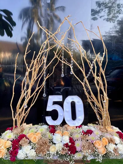 The full view of the 50th birthday centerpiece before the lights were turned on. The gold branches and fresh flowers create a beautiful rustic-glam look.