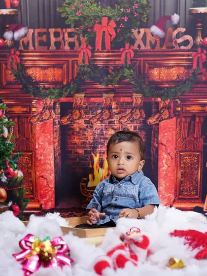 A classic Christmas fireplace scene created in the studio. This festive backdrop with a Christmas tree and decorations is perfect for holiday family photos.