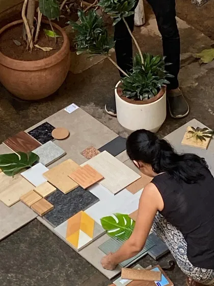 A team member carefully curates a material board, mixing tiles, wood samples, and stone to find the right combination.