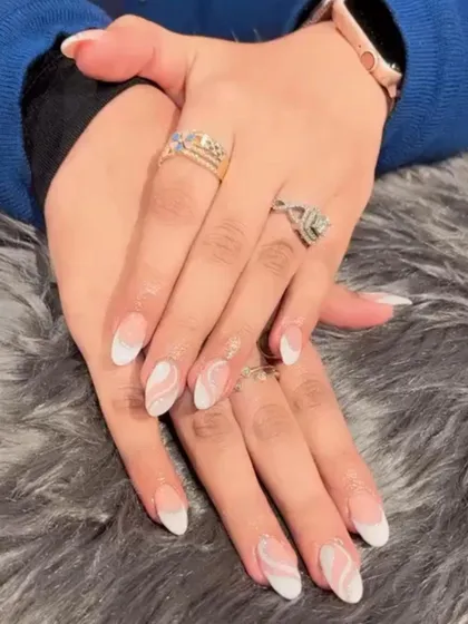 A beautiful white marble swirl design over a natural base, combined with classic white French tips for an elegant, mixed-media look.