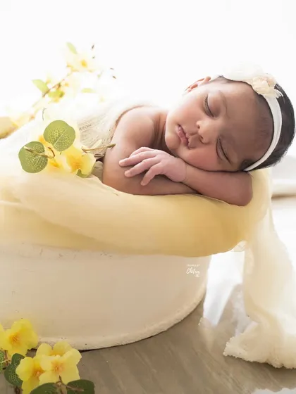 A side profile of the same yellow-themed setup, highlighting the baby's sweet, chubby cheeks and tiny features.