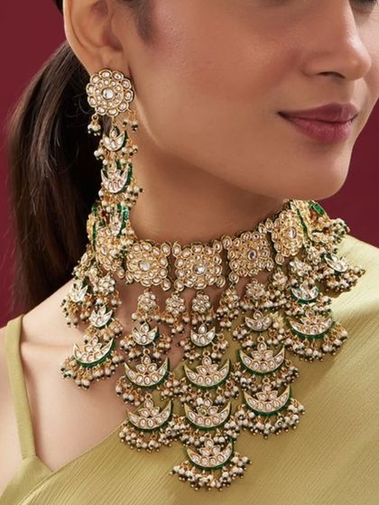A unique chandbali-inspired necklace with green enamel work and pearl drops. This set is perfect for someone looking for a distinctive design.