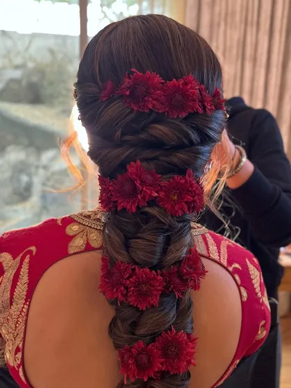 A close-up of the red chrysanthemum braid, showing the texture of the flowers and the hair.