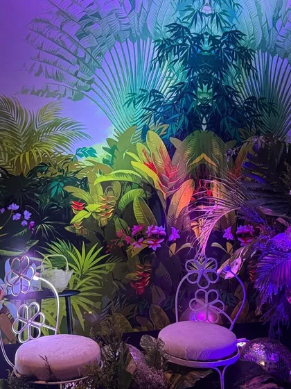 Another view of the jungle photo booth, this time with symmetrical lighting that creates a captivating visual effect on the tropical wallpaper. The design is both artistic and interactive.