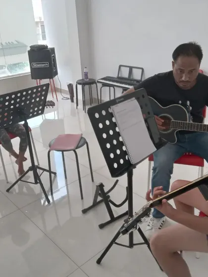 A guitar class with students learning together. Group classes are a great way to stay motivated.