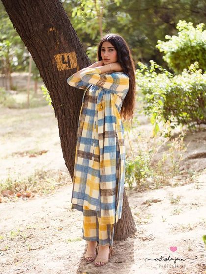 Another perspective of the plaid co-ord set, showing how the jacket moves with the model. Capturing different angles and poses provides a comprehensive view for the customer, helping them understand the garment's structure and versatility.