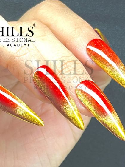 A full hand view of the stunning red and gold cat eye ombre nails, showing off their sharp stiletto shape.