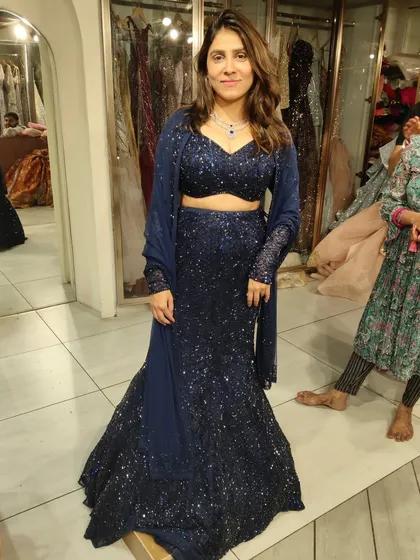 This client looks so chic in our navy blue sequin fish-cut lehenga. It's a popular choice for receptions and cocktail parties.