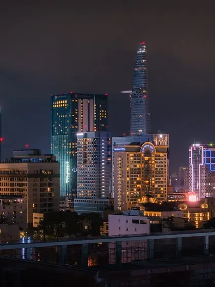 A beautiful shot of a Vietnamese city's skyline at night, showcasing a variety of modern architectural styles and colorful lighting.