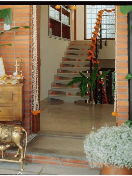 A view of the entrance to the house, decorated with jasmine garlands and a brass cow statue.