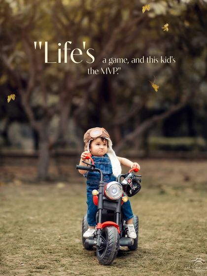 Life's a game, and this kid's the MVP. A cool little aviator gets ready for an adventure on his toy motorcycle in the park.
