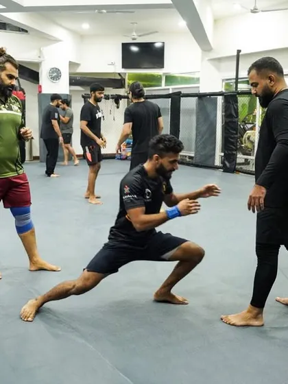 A moment of instruction and stretching during a class. Our coaches are always engaged, helping students improve their mobility and technique.