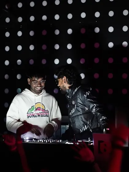 A candid moment of collaboration and fun behind the console with another DJ.