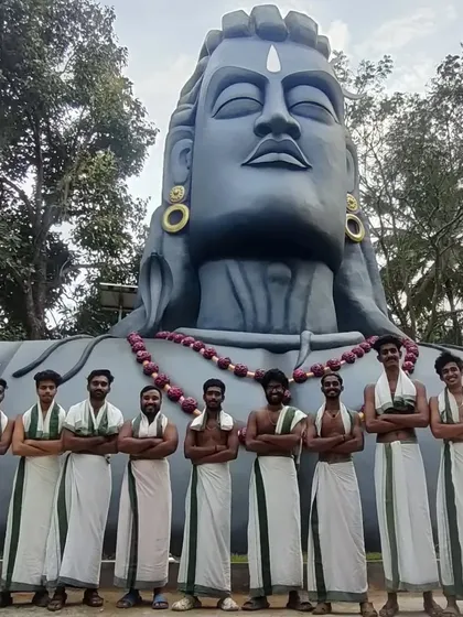 Our name, Mahadeva, reflects our spiritual connection to the art. Here is our team at the Adiyogi Shiva statue, a source of inspiration for our powerful rhythms.