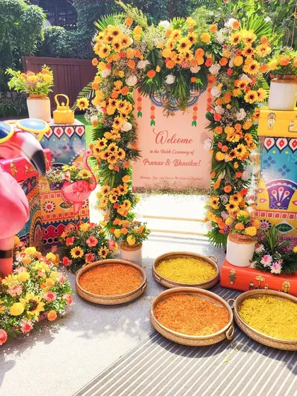 We love bringing vibrant energy to pre-wedding functions. This Haldi ceremony entrance features a playful theme with bright sunflowers, quirky flamingo props, and colorful hand-painted trunks.