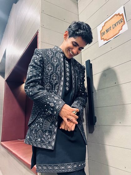 A candid shot of influencer Ahsan Vazir smiling in our detailed Indo-western jacket and kurta set. It's a versatile look that's both stylish and comfortable.