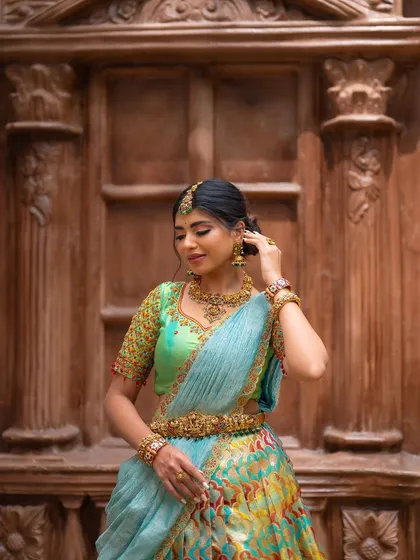 A candid shot of a model adjusting her jewelry. This natural moment adds a touch of authenticity to the traditional designer photoshoot.
