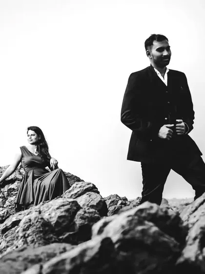 A dramatic, high-contrast black and white shot of Babita and Chetan on a rocky landscape. This shows how monochrome can enhance rugged, natural textures.