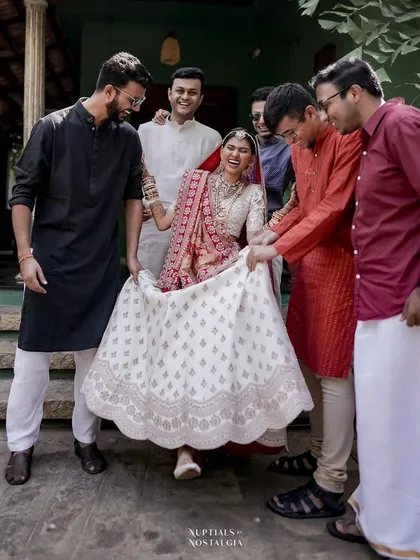 A Gujarati bride shares a fun, candid moment with her groomsmen.