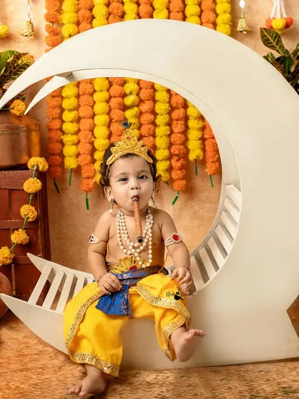 A playful little Krishna enjoying his flute while sitting on our moon prop. The details, like the peacock feather, add a special touch.
