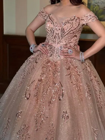A detailed shot of the bodice on our rose gold ball gown. The intricate patterns of sequins and beads create a luxurious texture, proving that this gown is all about opulent detail.