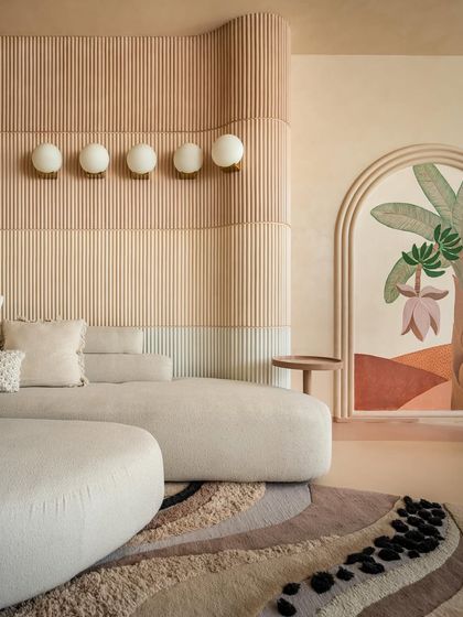 A close-up of the layered wall paneling in the "House of Mousse." The gradient of earthy tones and fluted texture adds depth and warmth, complemented by the soft glow of the wall-mounted lights.