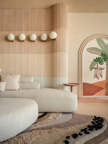 A close-up of the layered wall paneling in the "House of Mousse." The gradient of earthy tones and fluted texture adds depth and warmth, complemented by the soft glow of the wall-mounted lights.