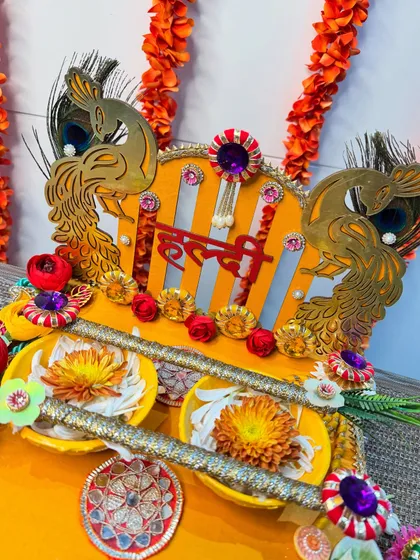 A close-up of the majestic peacock cutouts and floral details on our yellow Haldi platter. We love adding these traditional yet artistic elements to make your ceremony even more special.