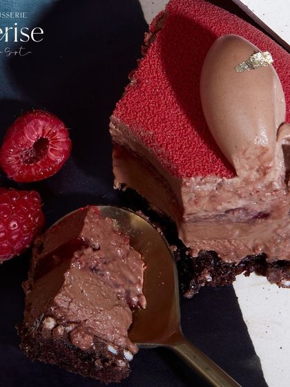A spoonful of the Choco Framboise, showing the smooth chocolate mousse and the vibrant raspberry layer.