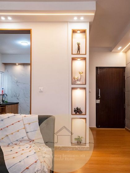 This living area features illuminated niches built into the wall, perfect for displaying art and decor. The warm lighting adds depth and character to the space, turning a simple wall into a design feature.