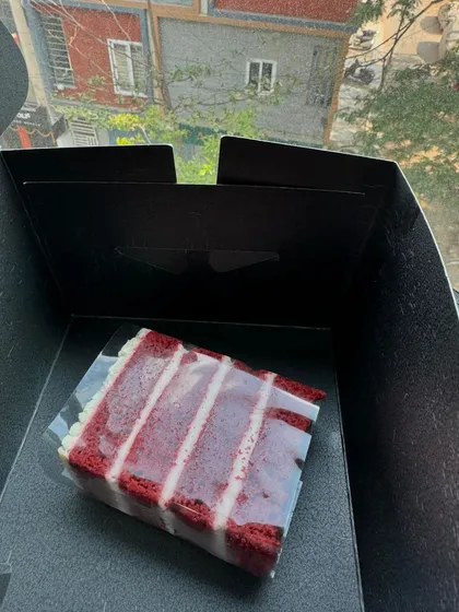 A single slice of our classic Red Velvet cake, with its vibrant colour and cream cheese frosting, ready to be boxed up.