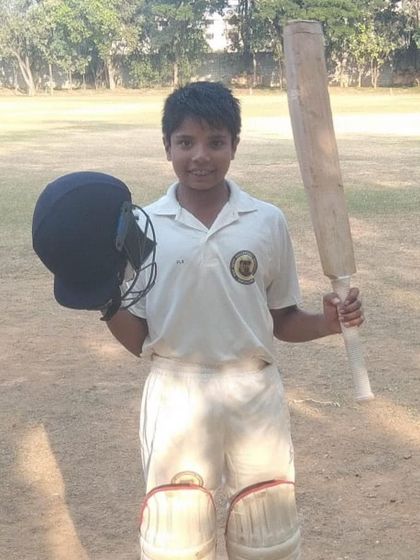 A proud pose after a match-winning century for his school team. This captures the essence of youth cricket.