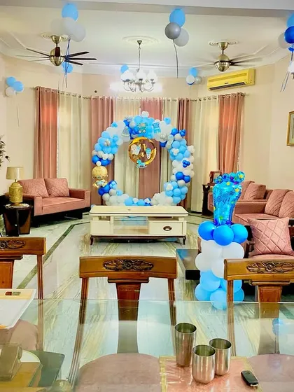 A wide shot of a living room decorated for a baby boy's welcome. This shows how I can work with your existing furniture to create a beautiful and cohesive party space.