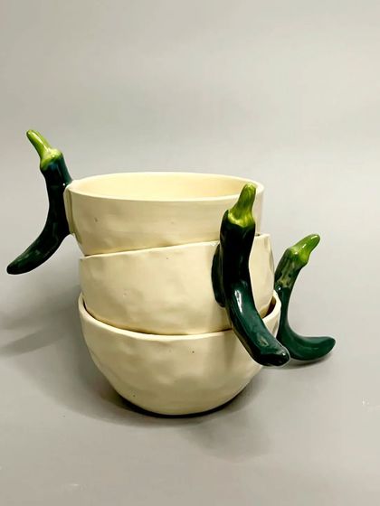 A stack of three chili mugs. These are perfect for adding a bit of fun and personality to your kitchen decor and daily rituals.