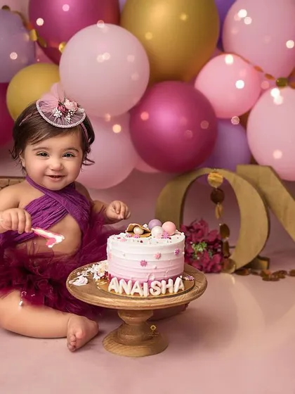 Celebrating one year with a pop of color! This vibrant balloon setup and personalized cake created the perfect party atmosphere for this little girl's milestone photos.