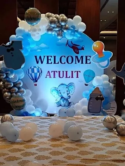A 'Welcome Atulit' baby celebration with a blue-themed backdrop featuring a cute elephant and hot air balloons.