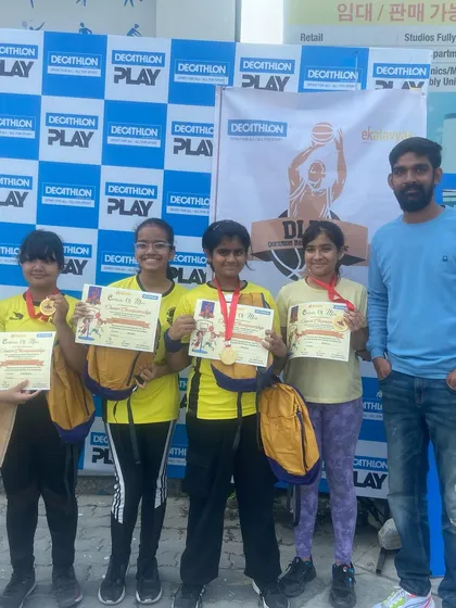 The Under-12 girls team proudly displaying their medals and certificates after a successful tournament.