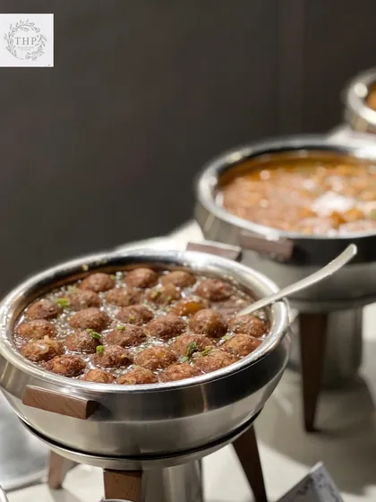A tempting view of our main course offerings. Here, a chafing dish is filled with delicious Manchurian balls in gravy, kept warm and ready for guests to enjoy at their leisure.