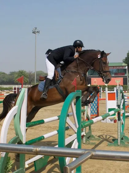 A rider demonstrates excellent form and balance while clearing a jump at a national competition. Our coaching focuses on creating effective and stylish riders.