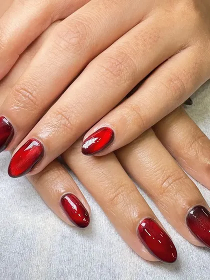 Another look at the fiery red cat-eye nail art. The magnetic polish creates a unique, light-reflecting band that moves and shifts, giving the nails a captivating, gem-like quality.