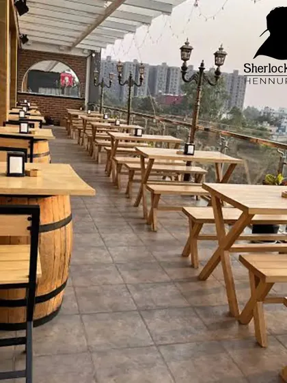 Welcome to my rooftop sports bar. I've set up long tables and benches so you and your squad can have plenty of space. It’s an open-air setup, perfect for enjoying the Bangalore weather while you watch the match.
