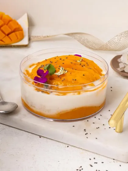 This mango and coconut tub dessert with chia seeds looks so refreshing. The styling with edible flowers and a white background gives it a healthy yet indulgent feel.