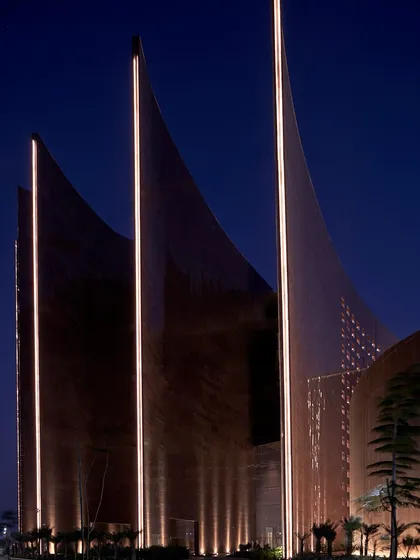 At night, the illuminated fins of the Surat Diamond Bourse highlight the building's dramatic architectural form. This lighting design emphasizes the verticality and sculptural quality of the fins, which are fundamental to the project's bioclimatic design strategy.
