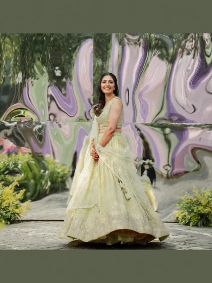 An artistic portrait of the bride at her Mehendi, set against a reflective, abstract background that adds a modern touch.