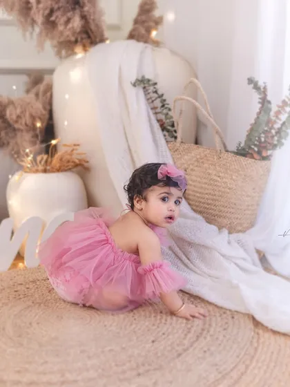 Capturing the crawling stage during a first birthday session. The 'ONE' sign in the background marks the special occasion.