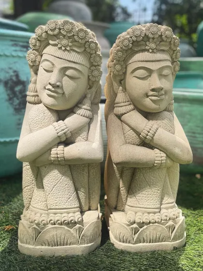 Our sandstone dolls, with their intricately carved floral headdresses, look beautiful in a sunny garden. The natural stone texture catches the light, highlighting the craftsmanship.