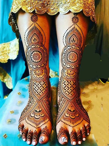 A classic and symmetrical full-foot design, featuring a central mandala, geometric jaali patterns, and an elegant border that extends up the leg.